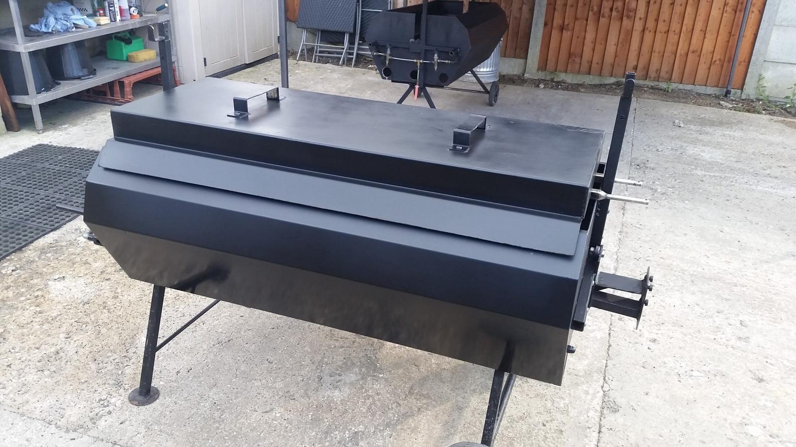 A black charcoal spit roast machine ready for hire