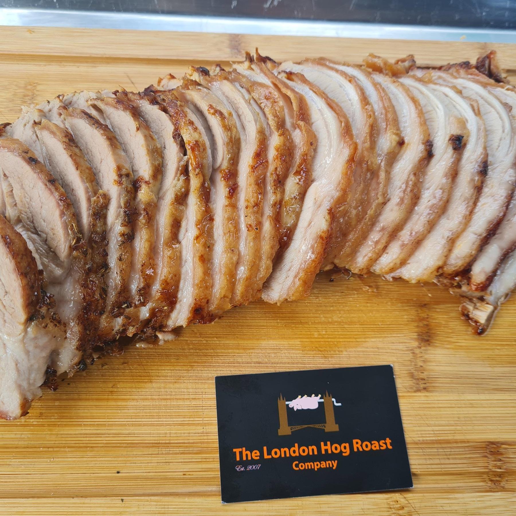 Carved roast pork loin fanned out on a board