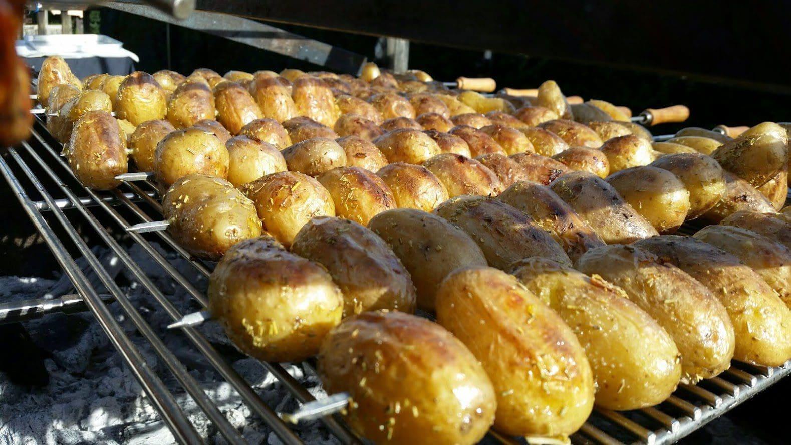 Rows of potatoes roasting on the grill