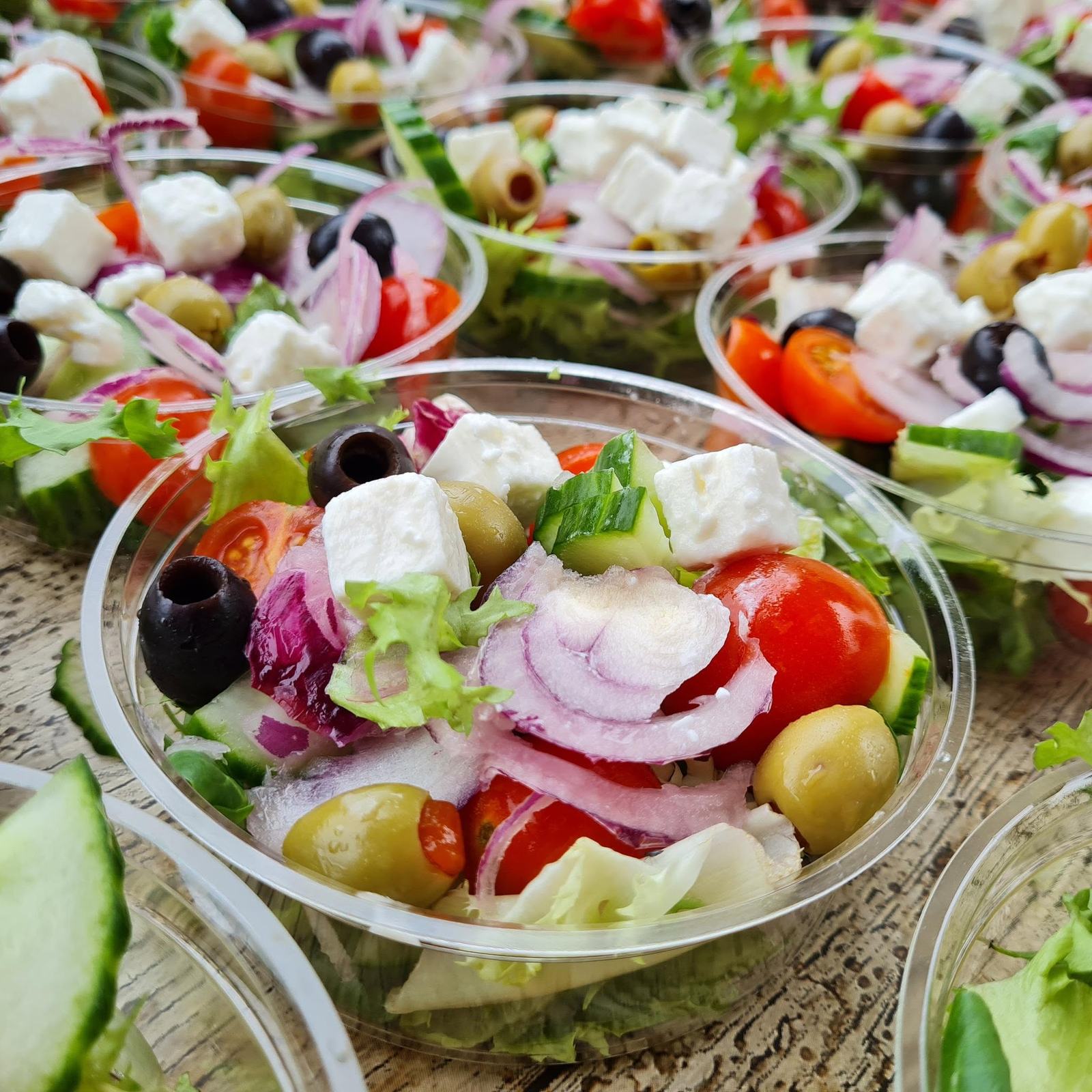 Individual pots of black olive and feta salad with cucumber and tomato