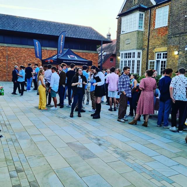 A queue for the hog roast at an evening event