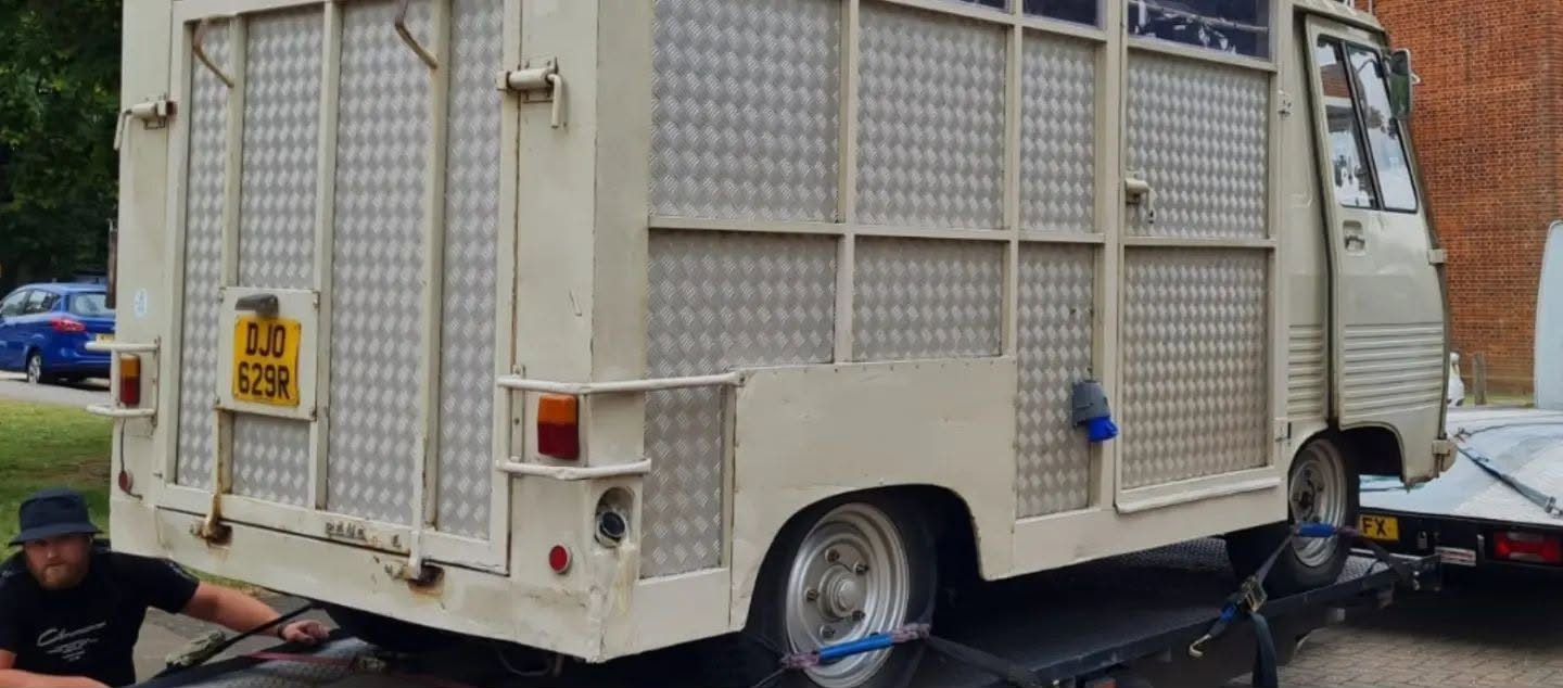 The Peugeot J7 arriving on a trailer with its old cream slatted body