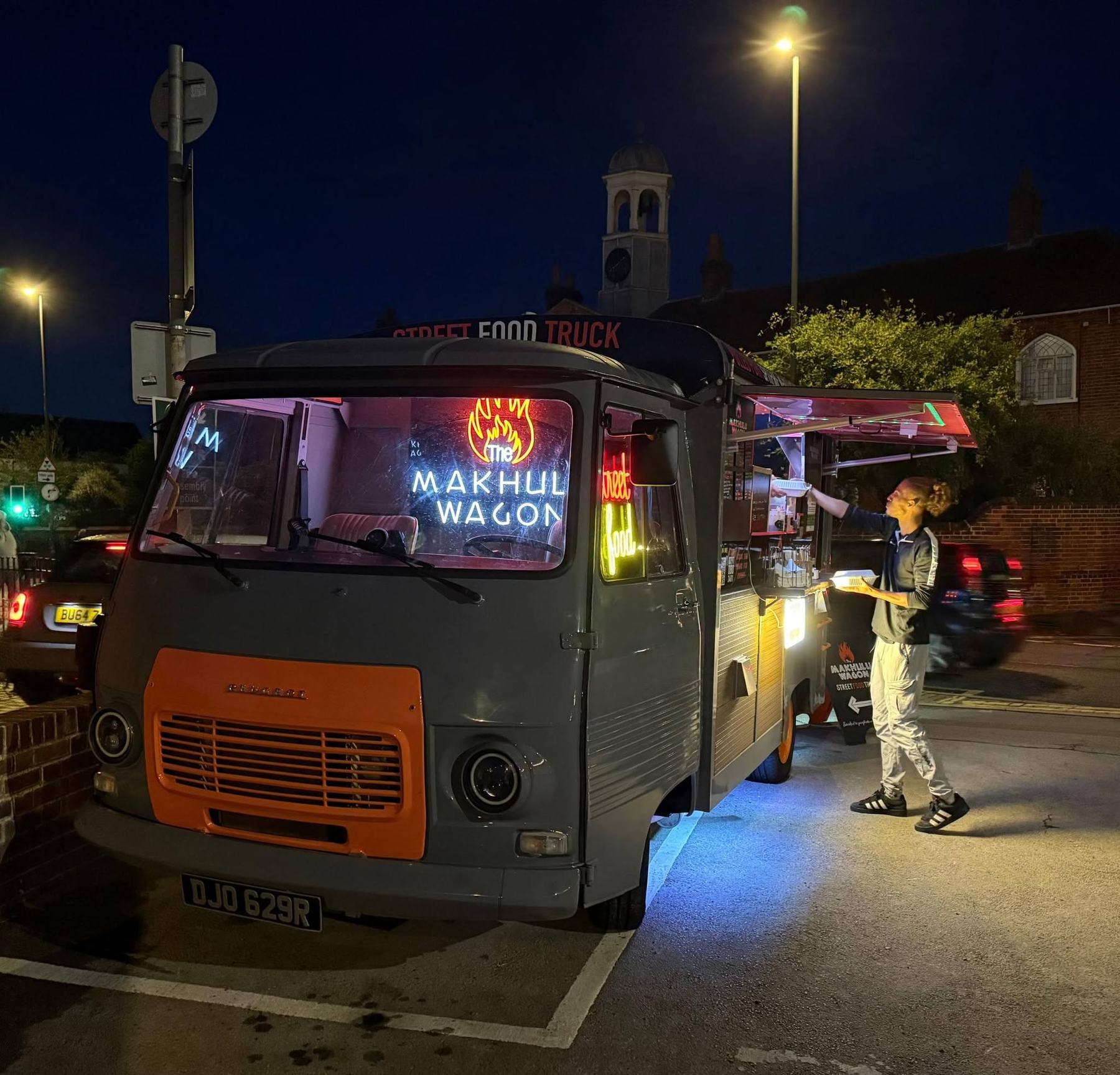 The wagon at night with its neon sign glowing in the windscreen